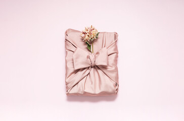 Gift box wrapped in reusable fabric, decorated dried flower.