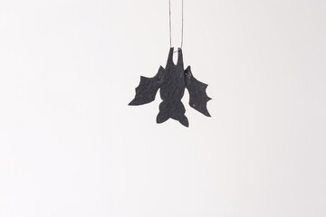 Minimal holiday decoration with bat on white background. Halloween celebration and home decor...