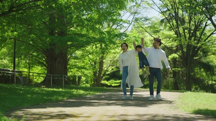 Fototapeta premium 公園で手を繋いで歩く家族