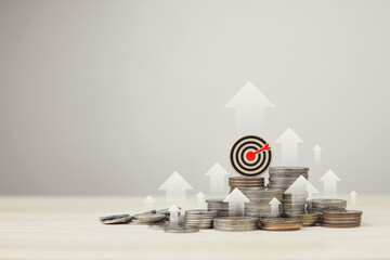 Stack of silver coins,  and target board with rising arrow. Investment management concepts,...