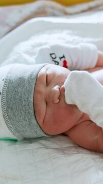 Adorable newborn child in the maternity hospital. Pediatrician listens to the heartbeat of an infant. Nurses take care of a baby. Vertical video