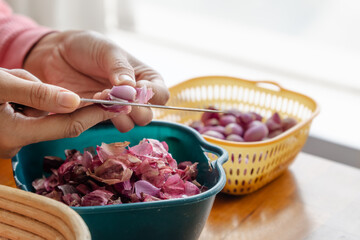 hand peeling shallot with a knife in a kitchen