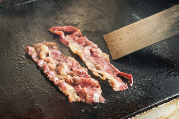 beef bacon grilled on a flat griddle