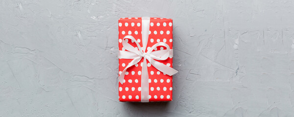 Fototapeta premium Valentine day composition: red gift box with bow and heart. Christmas present. View from above. Space for text. Holday greeting card