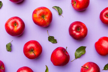 Many red apples on colored background, top view. Autumn pattern with fresh apple above view
