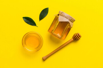 Honey jar with wooden honey dipper on white background top view with copy space. Delicious honey bottle