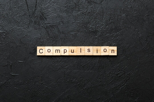 compulsion word written on wood block. compulsion text on table, concept