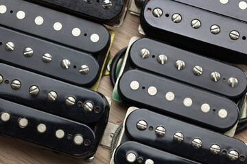Humbuckers. Electric guitar humbucker type magnetic pickup (double coil ) on ash lumber wood background. electric guitar maintenance and spec up. Black bobbin. © killykoon