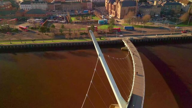 Ascending aerial shot of the Peace Bridge in Derry-Londonderry. Filmed on a sunny day in 4K, 60 frames per second and in Rec709 color.
