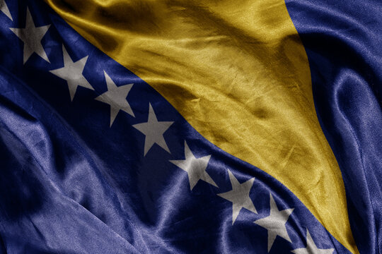 shine waving colourful realistic national flag of bosnia and herzegovina . macro shot