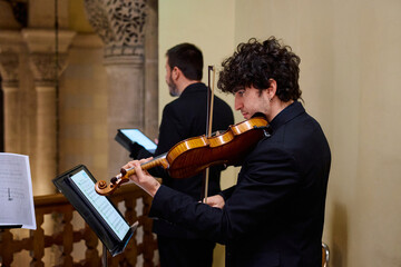 Violinist performing at an evening concert in an ornate church setting