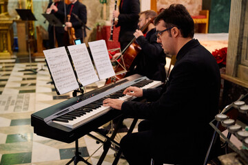 Concert in a church featuring musicians performing classical pieces on a keyboard