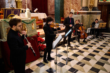 Musicians perform classical music during a concert in a historic church setting