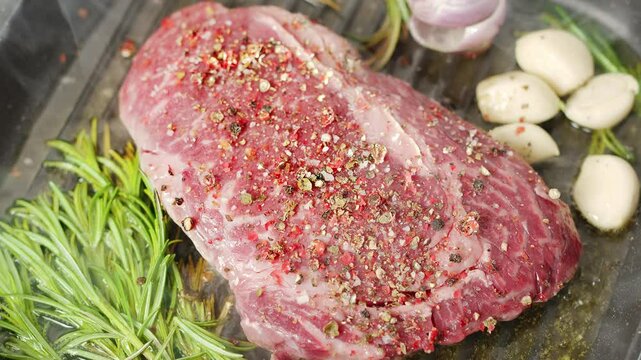 Ribeye steak with herbs and garlic are being roasted on the grill pan. 