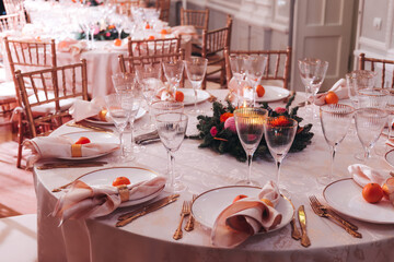 Beautiful table decoration for luxury  event in pink and gold, cutlery and tableware, banquet hall arrangement decor, celebration in restaurant with flowers, candles on a wedding reception party