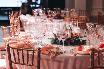 Beautiful table decoration for luxury  event in pink and gold, cutlery and tableware, banquet hall arrangement decor, celebration in restaurant with flowers, candles on a wedding reception party