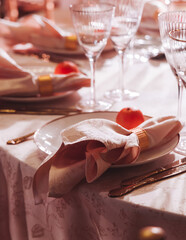 Beautiful table decoration for luxury  event in pink and gold, cutlery and tableware, banquet hall arrangement decor, celebration in restaurant with flowers, candles on a wedding reception party