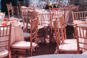 Beautiful table decoration for luxury  event in pink and gold, cutlery and tableware, banquet hall arrangement decor, celebration in restaurant with flowers, candles on a wedding reception party