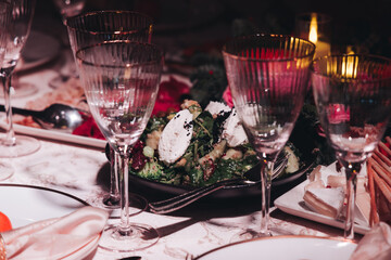 Beautiful table decoration for luxury  event in pink and gold, cutlery and tableware, banquet hall arrangement decor, celebration in restaurant with flowers, candles on a wedding reception party