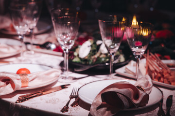 Beautiful table decoration for luxury  event in pink and gold, cutlery and tableware, banquet hall arrangement decor, celebration in restaurant with flowers, candles on a wedding reception party