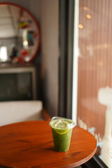 a cup of ice matcha on the wood table
