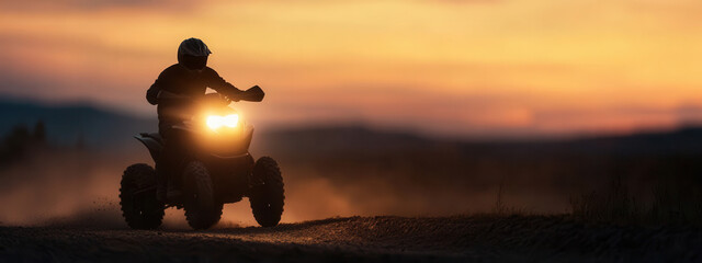 A rider navigates a quad bike on a dusty trail during sunset, capturing the thrill of off-road adventure in the fading light