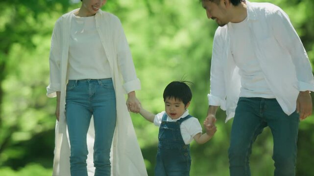 公園で手を繋いで歩く家族