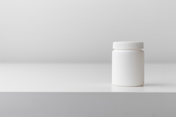 White plastic medicine bottle on a white background with copy space. Medicine and health concepts include a jar with pills or vitamins. High-quality photo mock-up banner