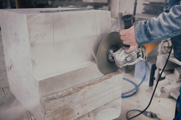 A stonemason working on a statue base