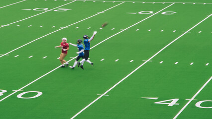 American Football Players Face Each Other On the Field. Athlete Making a Big Catch in Front of an Opponent