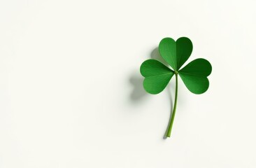 A minimalist St. Patrick's Day card featuring a single, perfectly drawn four-leaf clover in dark emerald green on a pure white background 