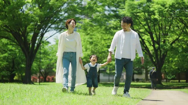 公園で手を繋いで歩く家族