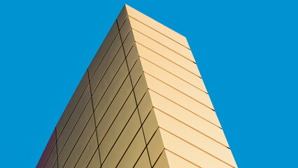 fragment of the wall of a modern yellow building on a blue background