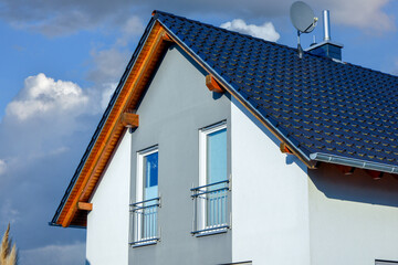 Fassade eines modernen Einfamilienhaus-Neubaus mit Giebeldach und Ziegeldeckung