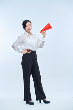 여성 회사원이 정장을 입고 빨간색 확성기를 들고  포즈를 취하고 있다. 