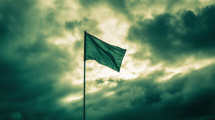 Green flag waving in overcast sky