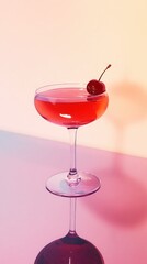 Bright red non-alcoholic beverage with cherry sits on a reflective surface in an elegant setting