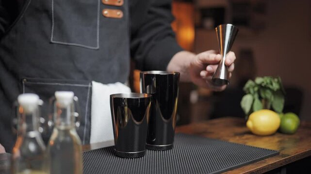 Slow motion of bartender showing his jigger. Presenting his cocktail equipment. Perfect for bartending tutorials and drink promotions.
