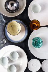 Top view of an empty plates, bowls and glasses placed on a black chalkboard background. Flat lay. Top view. Food concept.