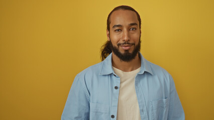 Obraz premium Young arab man with beard smiling in casual attire over isolated yellow background