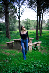 Naklejka premium Chica joven delgada vloggeando con cámara por zona verde con arboles