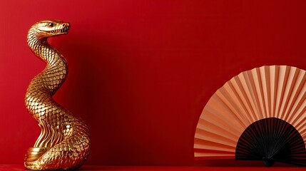 A red background wall with paper fans and a gold cobra sculpture on the left side, a Chinese New Year concept with space for text or design. 