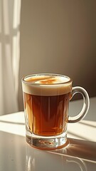 Glass mug of espresso with crema in sunlit room interior
