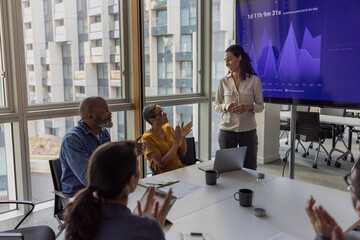 African American businesswoman being applauded for her presentation in a corporate meeting