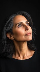 Fototapeta premium Confident 60 years old woman in black attire against dark background