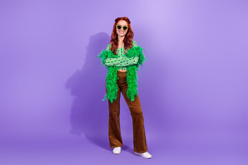 Stylish young woman with red hair in trendy outfit posing with vivid colors and joyful disco vibes