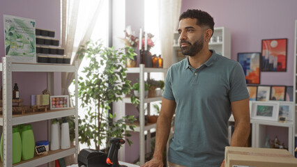 Fototapeta premium Young man standing in a home decor store surrounded by various decorations and plants