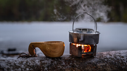 Boiling water in a kettle on a portable solid fuel stove in the forests a rainy day