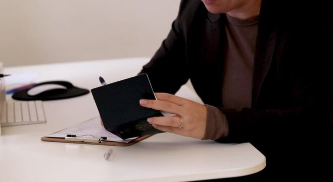 Close up of a caucasian woman filling out visa application documents with an American passport on a office table