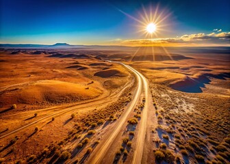 Fototapeta premium Endless Desert Tracks: Aerial Drone View of Winding Road Through Arid Landscape
